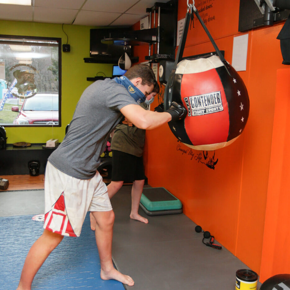 Man in boxing class training on bag