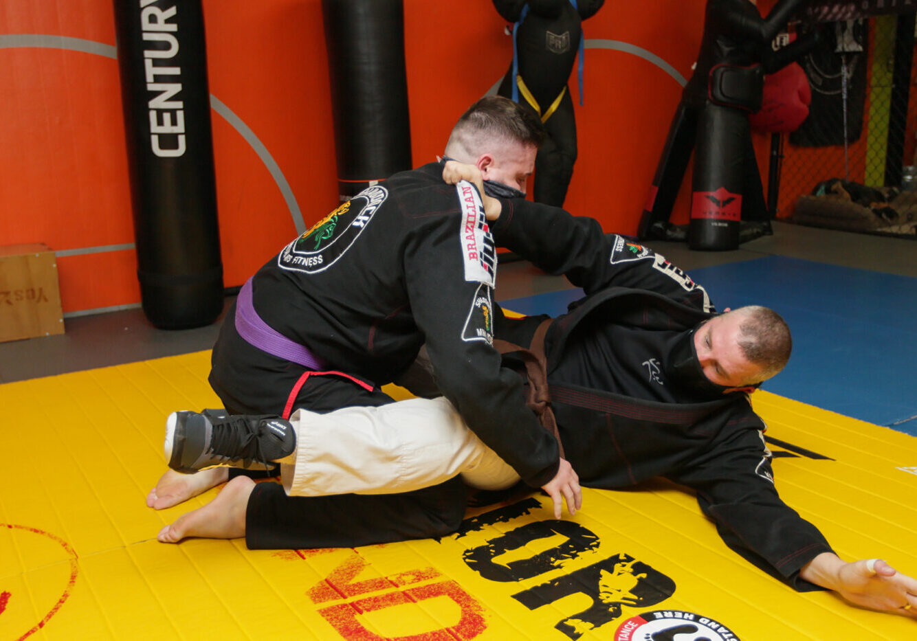 two men on the mat doing Brazilian Jiu Jitsu